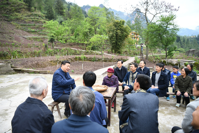 习近平在石柱土家族自治县中益乡华溪村同村民代表、基层干部、扶贫干部、乡村医生等围坐在一起，共话脱贫攻坚。